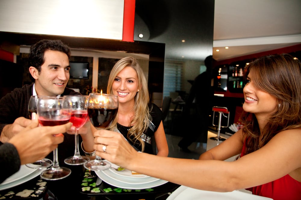 Group of people toasting looking happy at a fancy restaurant